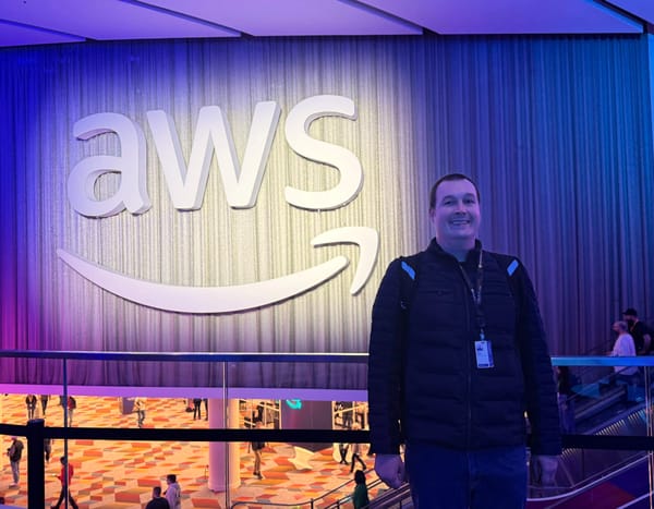 A A picture of Chris Ebert sending in front of a large AWS logo at the AWS re:Invent 2024 conference